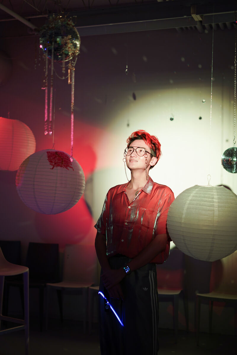 Portrait of Yiwei Leo Wang beneath a mirror ball